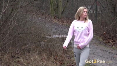 Blonde babe Claudia pisses down a drain outside